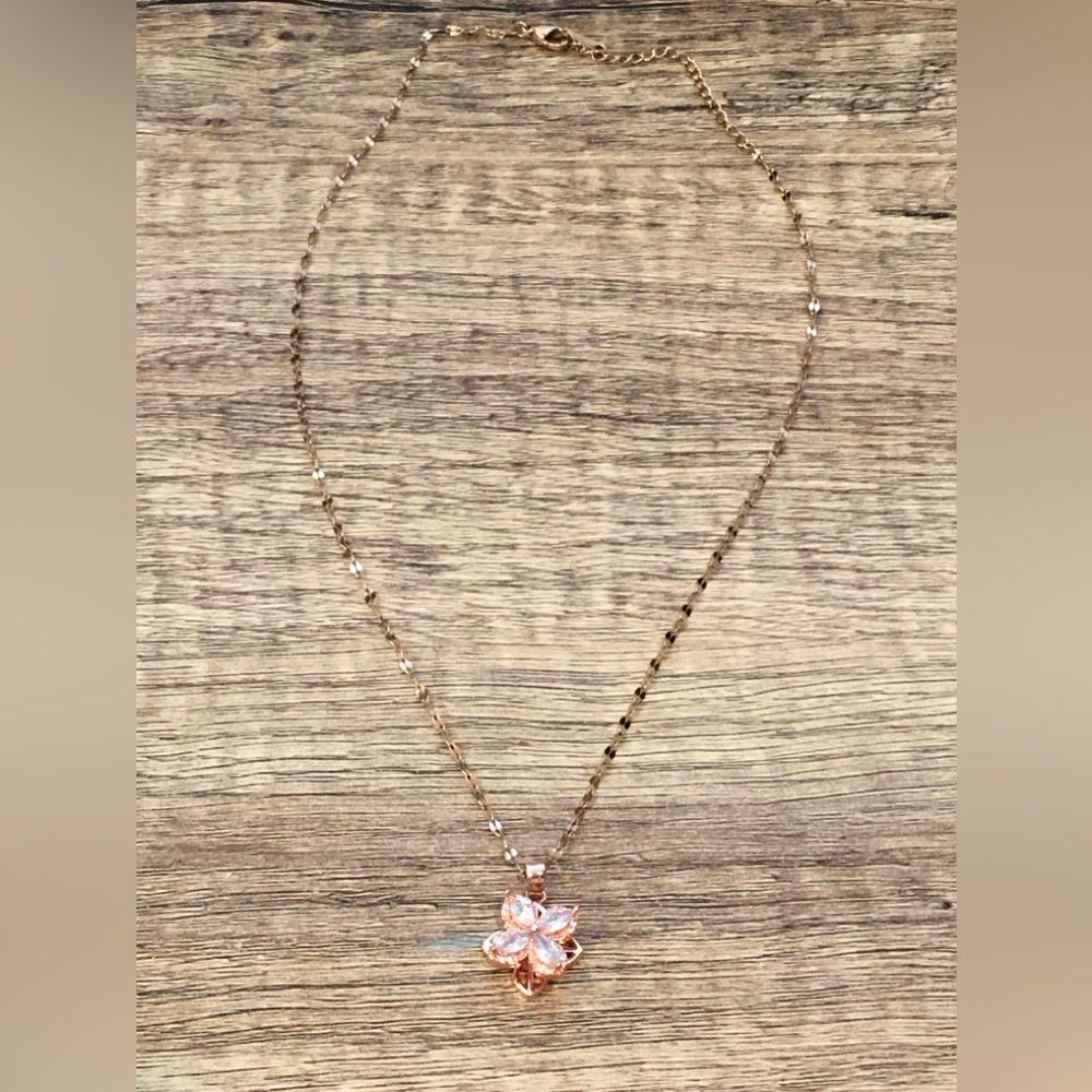 Rose gold stainless steel necklace with spinning clover pendant.